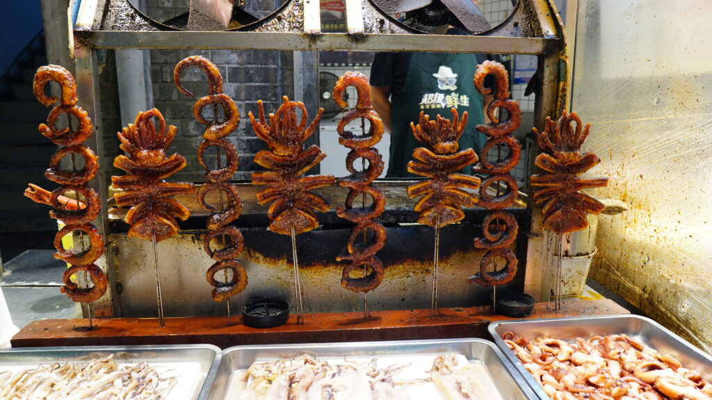 A grill with various types of food, including fried octopus.