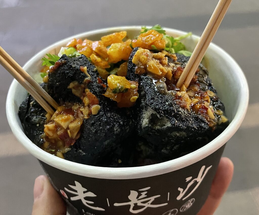 A hand holding a cup of food in Wuhan.