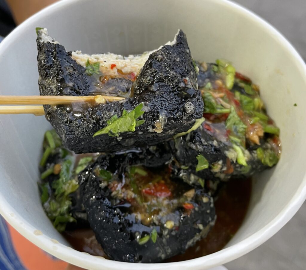 A person holding chopsticks in a cup of food in Wuhan.