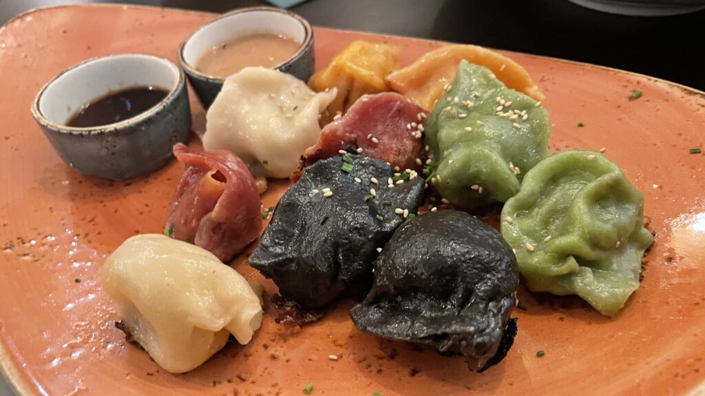 Delicious colourful dumplings served on a plate with a choice of tasty sauces