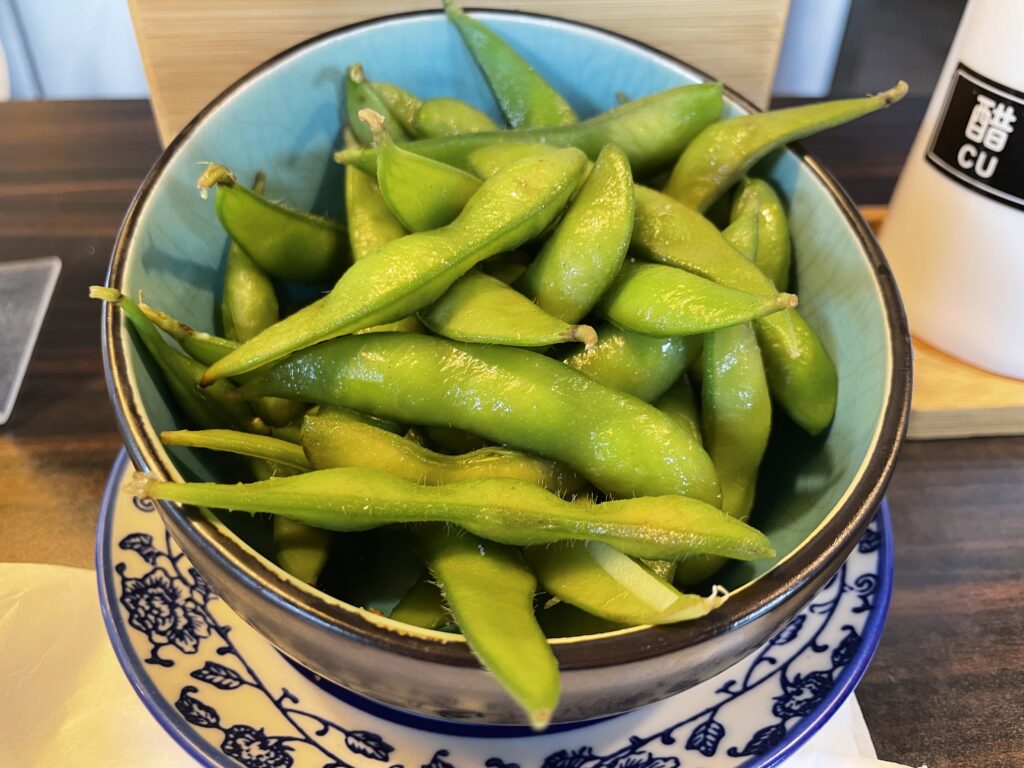 A bowl of edamame on a wooden table