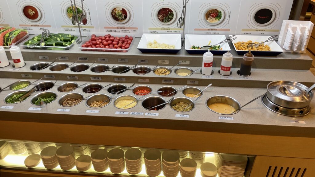 Different types of dipping sauce ingredients displayed on a counter at Haidilao Hotpot in Wuhan.