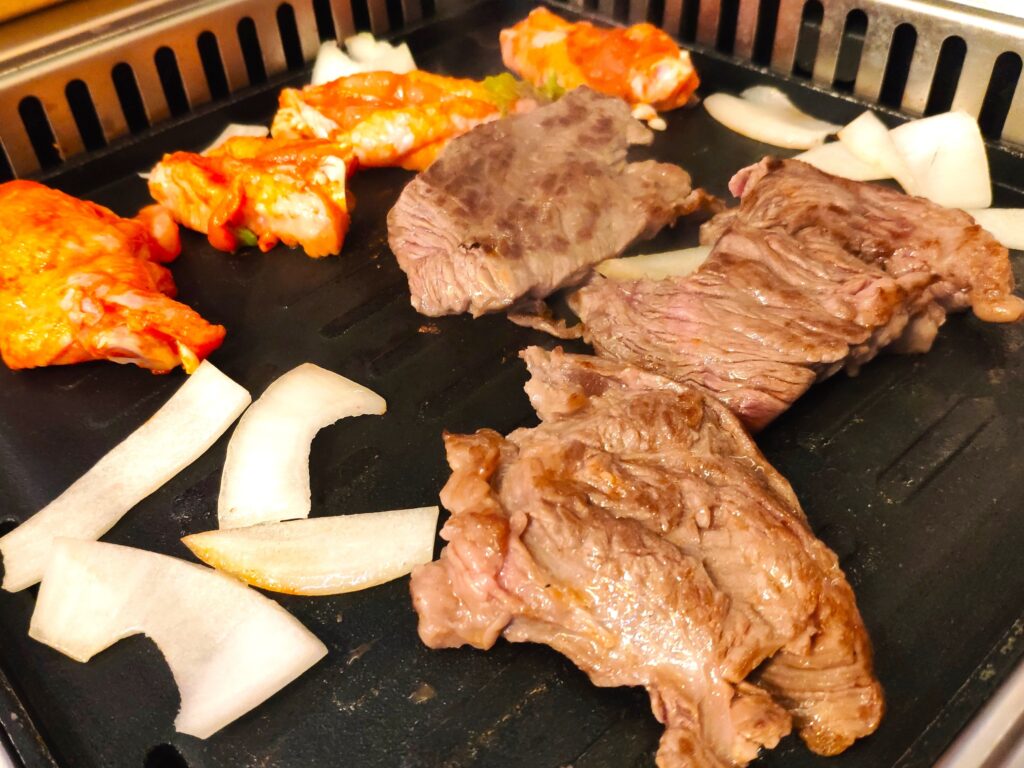 A Chinese barbecue in Frankfurt, with a grill on which meat and onions are sizzling