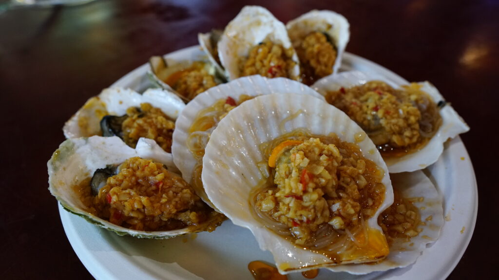 A plate of clams served with rice and spicy sauce.