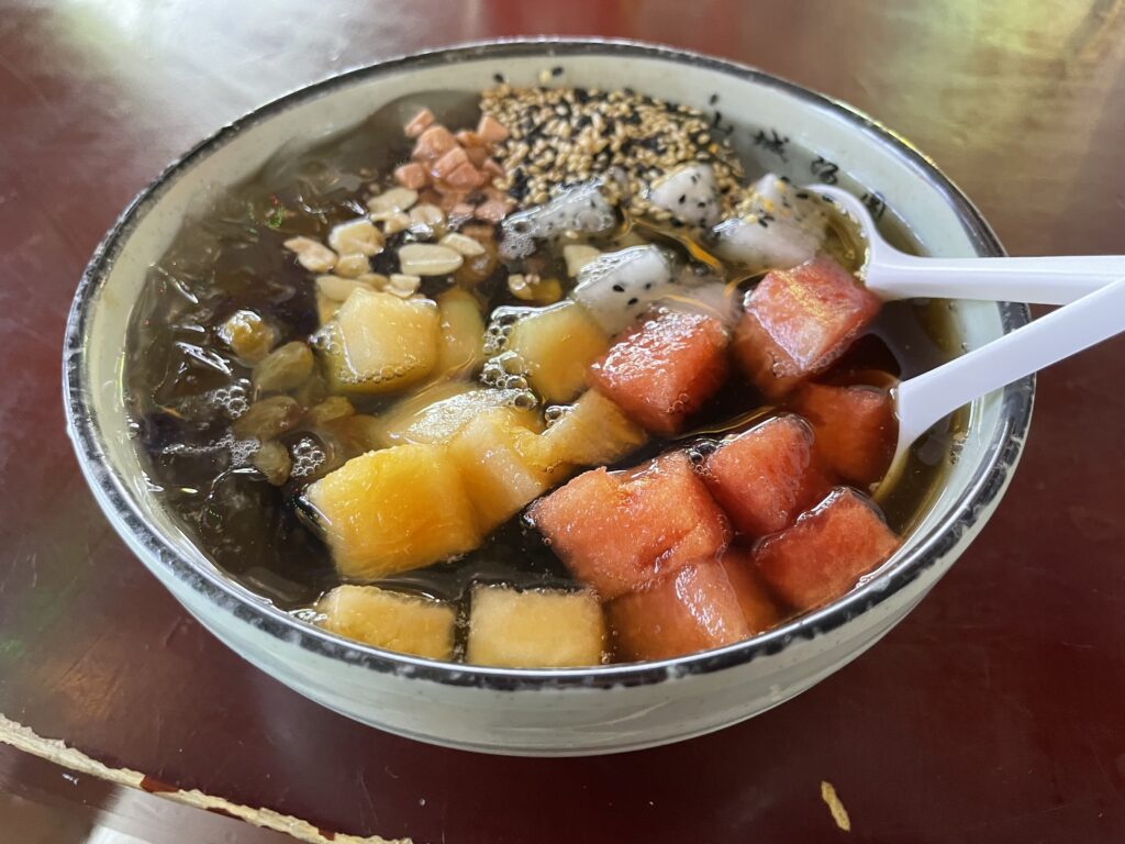 A bowl of bingfen and colourful fruits at a street food stall in Wuhan.