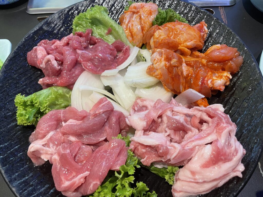 A plate of meat and vegetables on a table at a Chinese barbecue and hotpot restaurant in Frankfurt