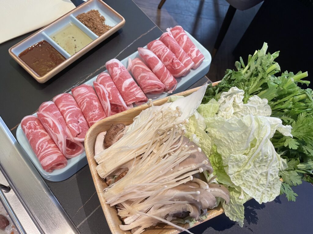 Ingredients of a Chinese barbecue in Frankfurt on a table, including meat, vegetables and sauces