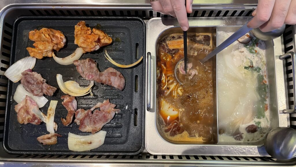 On the left is a barbecue with sizzling meat and vegetables. On the right, someone is cooking meat in a pan, holding it with chopsticks