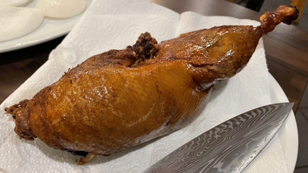 A plate with a knife next to a large piece of authentic Peking duck at Restaurant Yung in Frankfurt