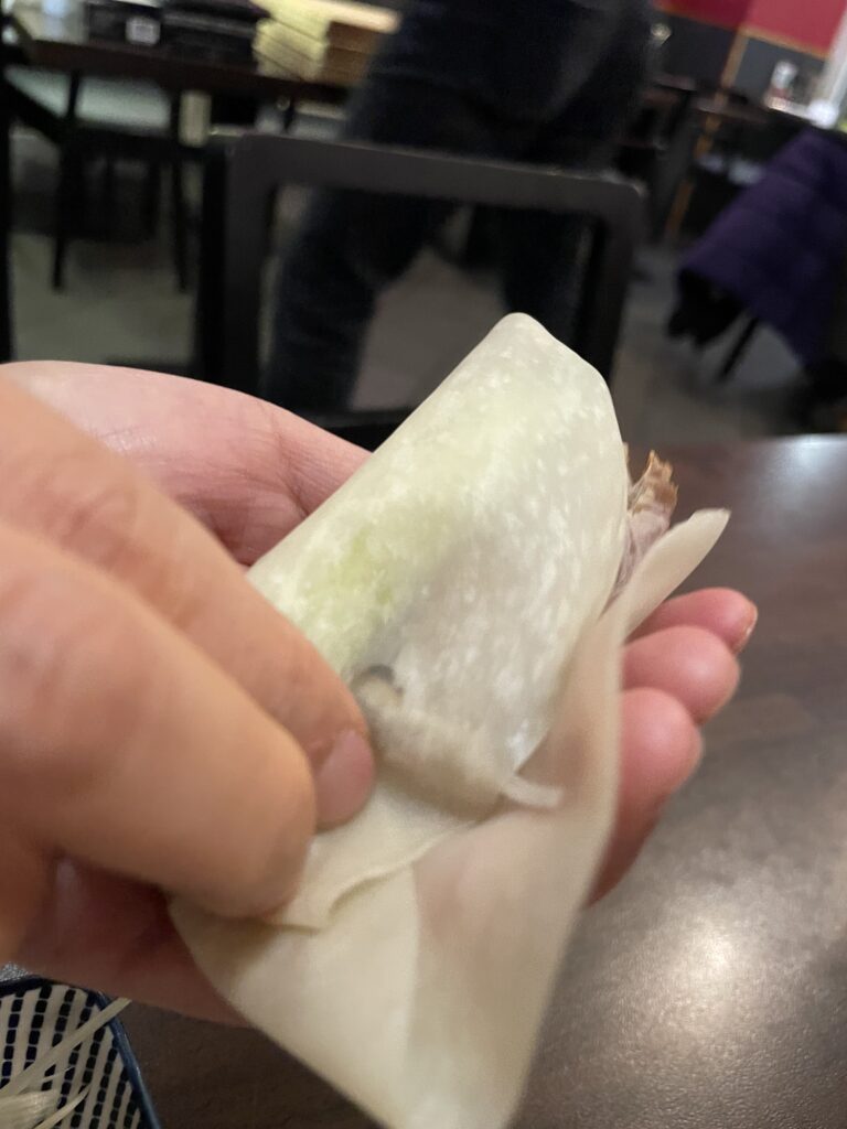 A person wrapping Peking duck