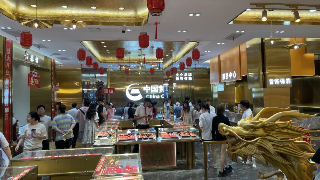 A busy shop in Wuhan selling gold, filled with customers browsing the merchandise.