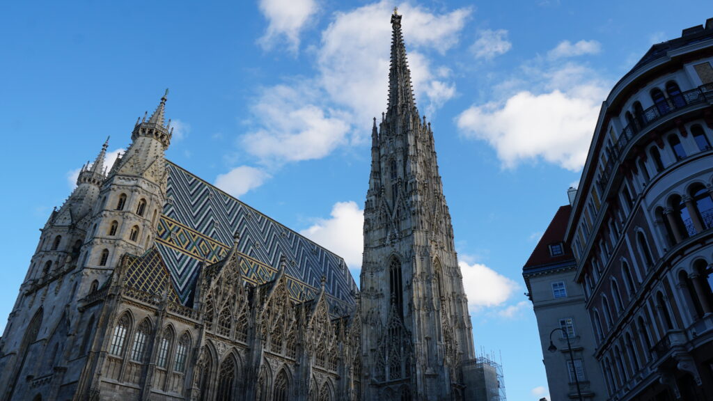 Majestic steeple of St. Stephen's Cathedral (Stephansdom) in Vienna against a clear blue sky.