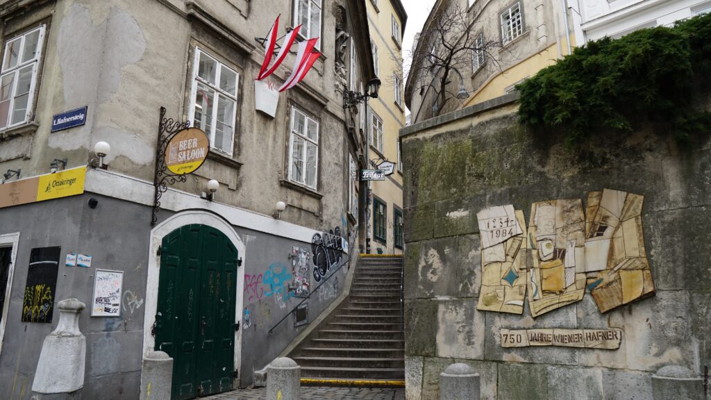 A charming narrow street with a modern art wall in the historic center of Vienna.