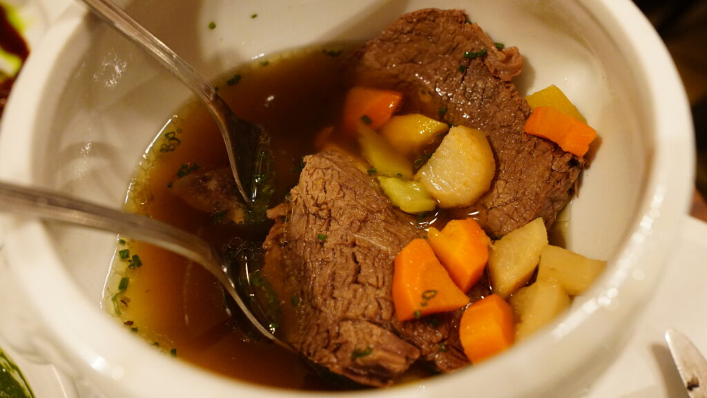 Image of a bowl of Tafelspitz with meat, vegetables and soup for our Vienna travel and food guide.