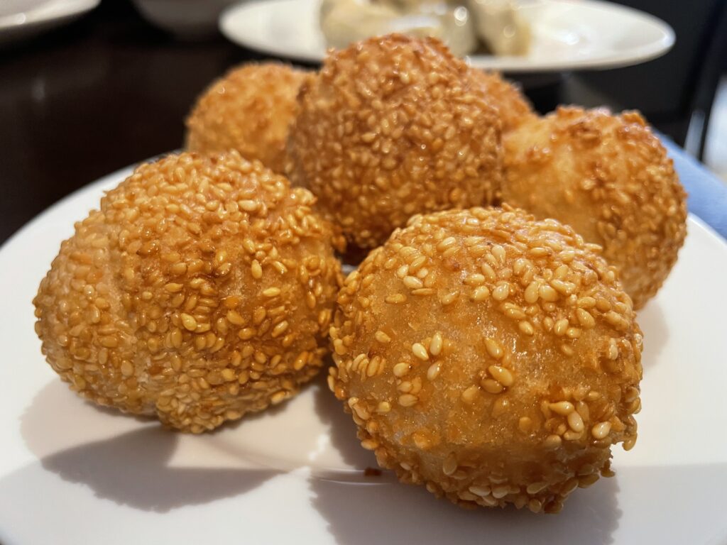 Sesame balls filled with red bean paste on a plate.