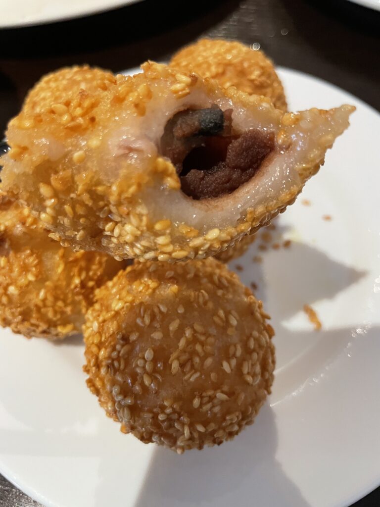 A plate of sesame balls stuffed with red bean paste, neatly arranged for an appetizing presentation.